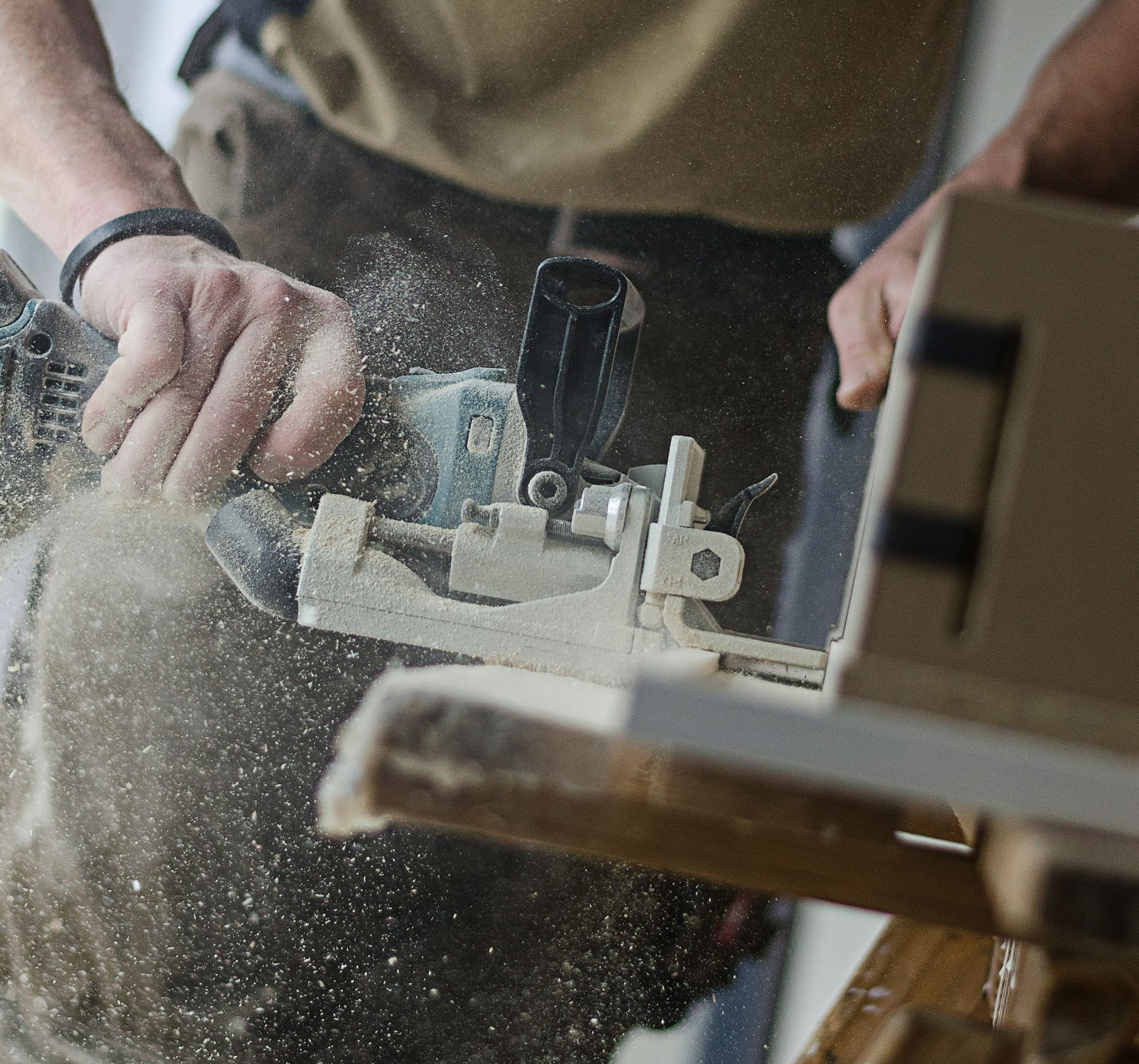 Joiner cutting a biscuit joint in a timber board