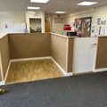 L-shaped reception counter with a door, framed and boarded in an office, before decorating